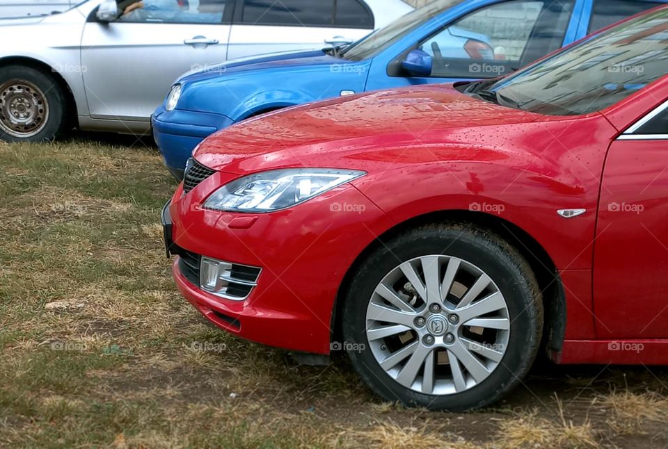 front of red and blue car.