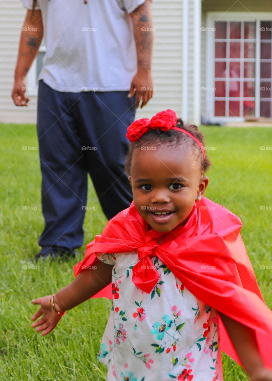 Smiling young girl in red cape