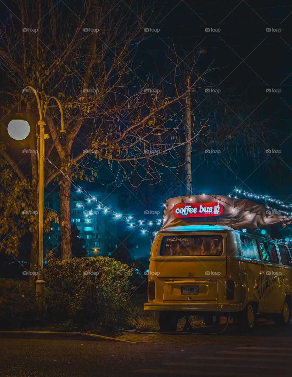 The coffee bus is illuminated at night