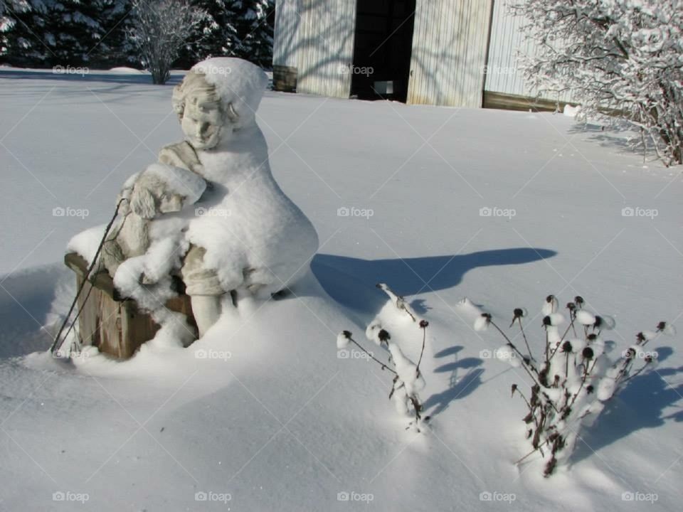 Garden decorations covered in snow after a storm.