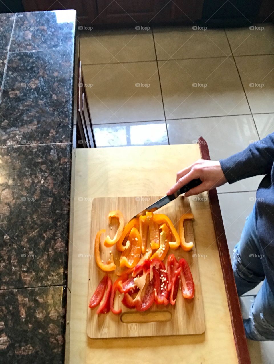 Chopping up bell peppers in the kitchen on the cutting board for a healthy meal. 