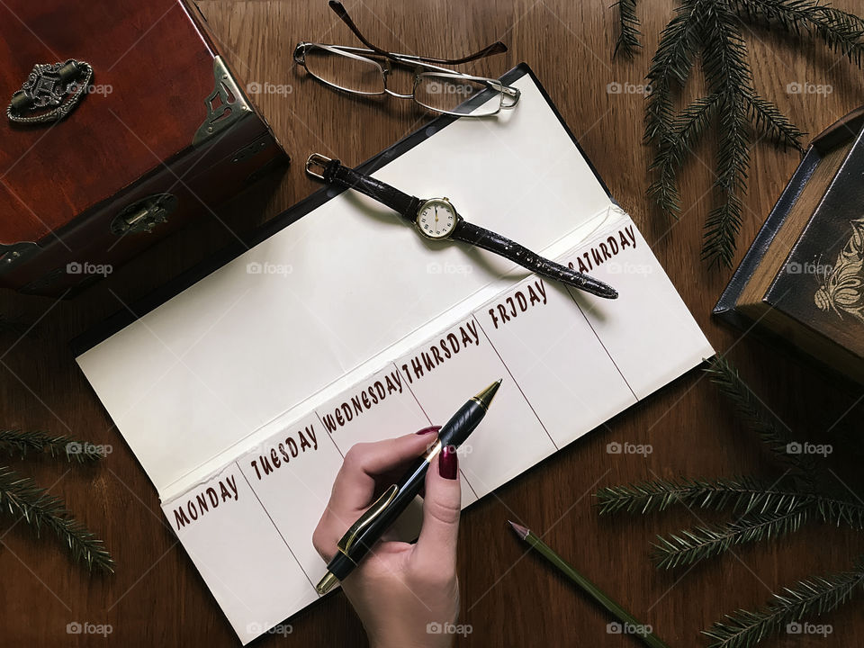 Business woman writing in calendar 