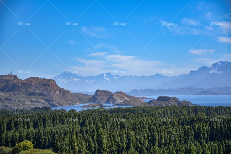 general carrera lake with trees and cerro castillo in the background in chilean patagonia