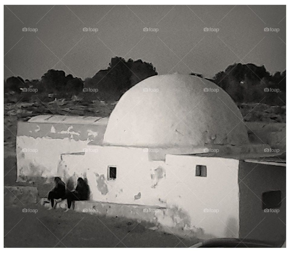 A picture from a beach on the island of Djerba, where the old buildings stad with their domes painted in white
It is part of the local heritage
On a bench built behind the building two girls are sitting whispering at sunset