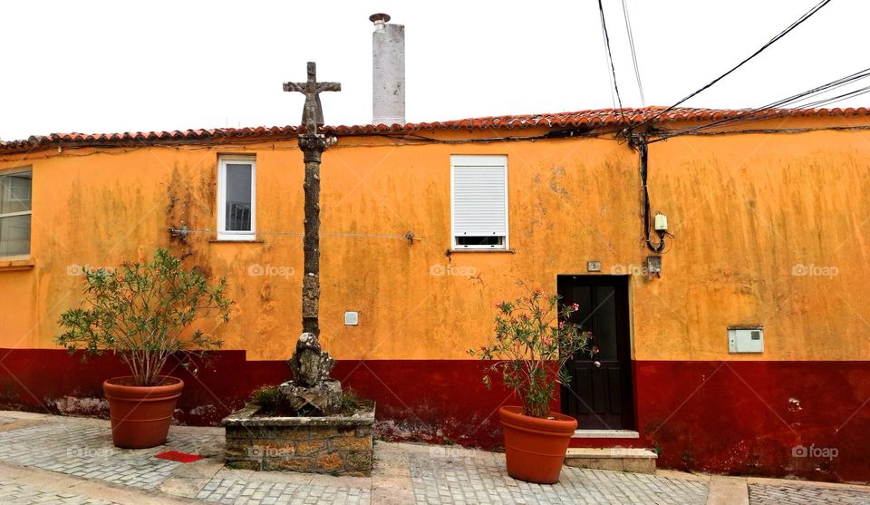 Village street with an old granite cross and a fisherman's house.  Palmeira, Spain.