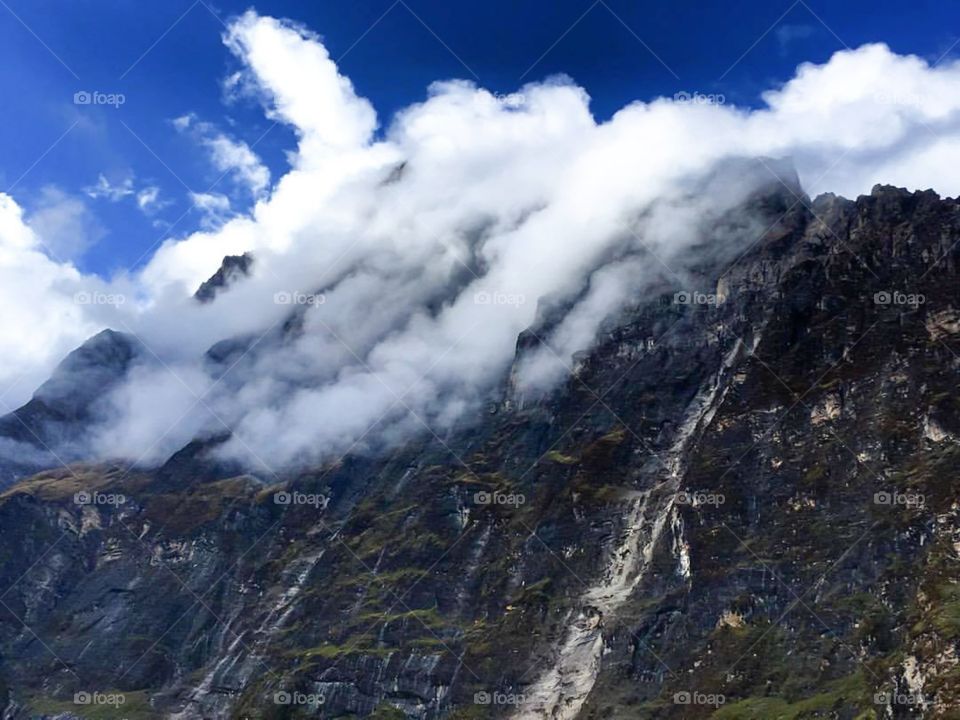 The Hand Of God. The clouds roll over the mountains surrounding Italian Base Camp on the Dhaulagiri Circuit Trek in Nepal.