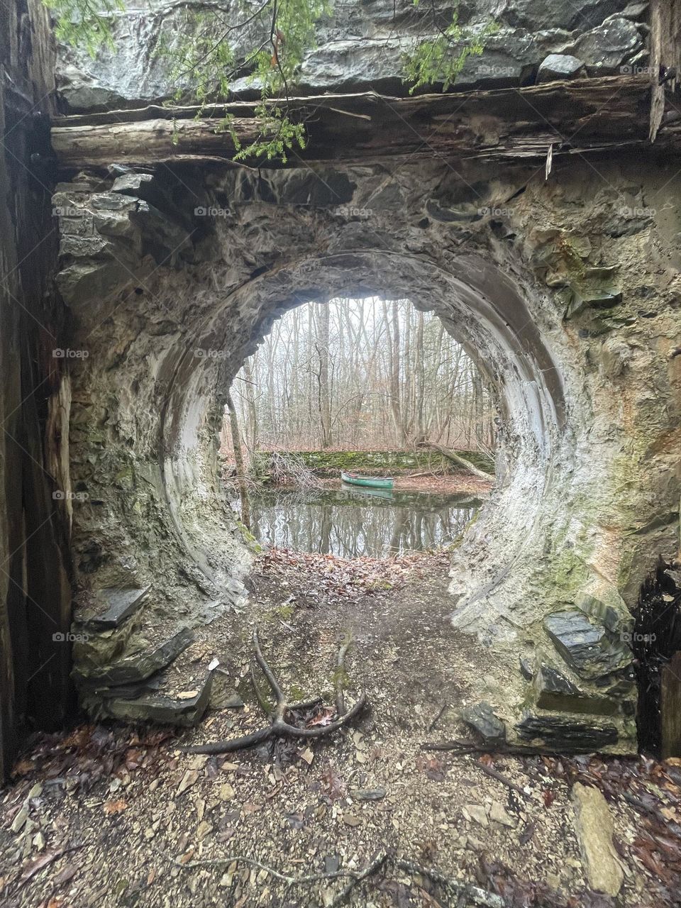 Green canoe framed by stone arch