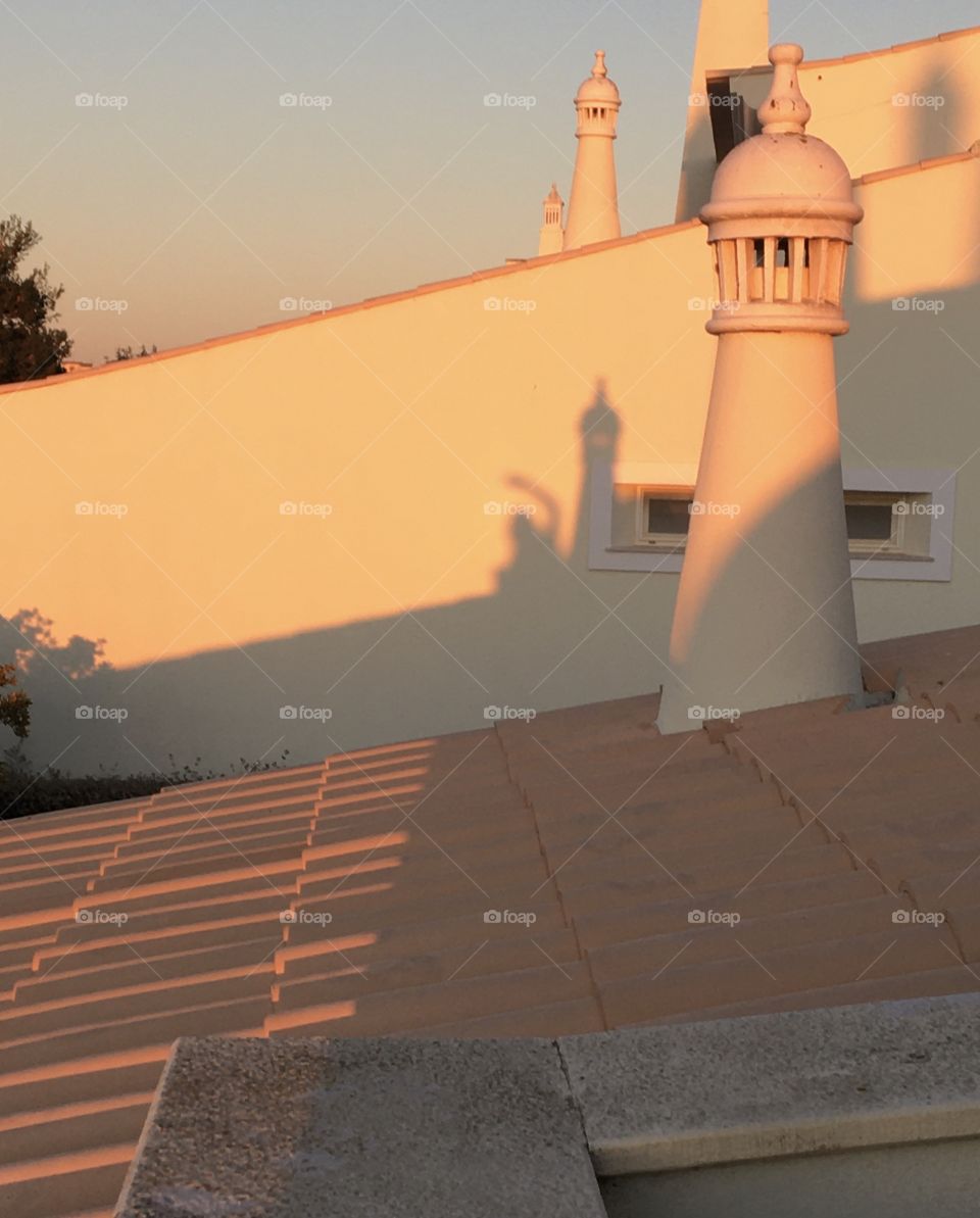 « good morning » with shadows of chimney and people at rising sun on rooftops 