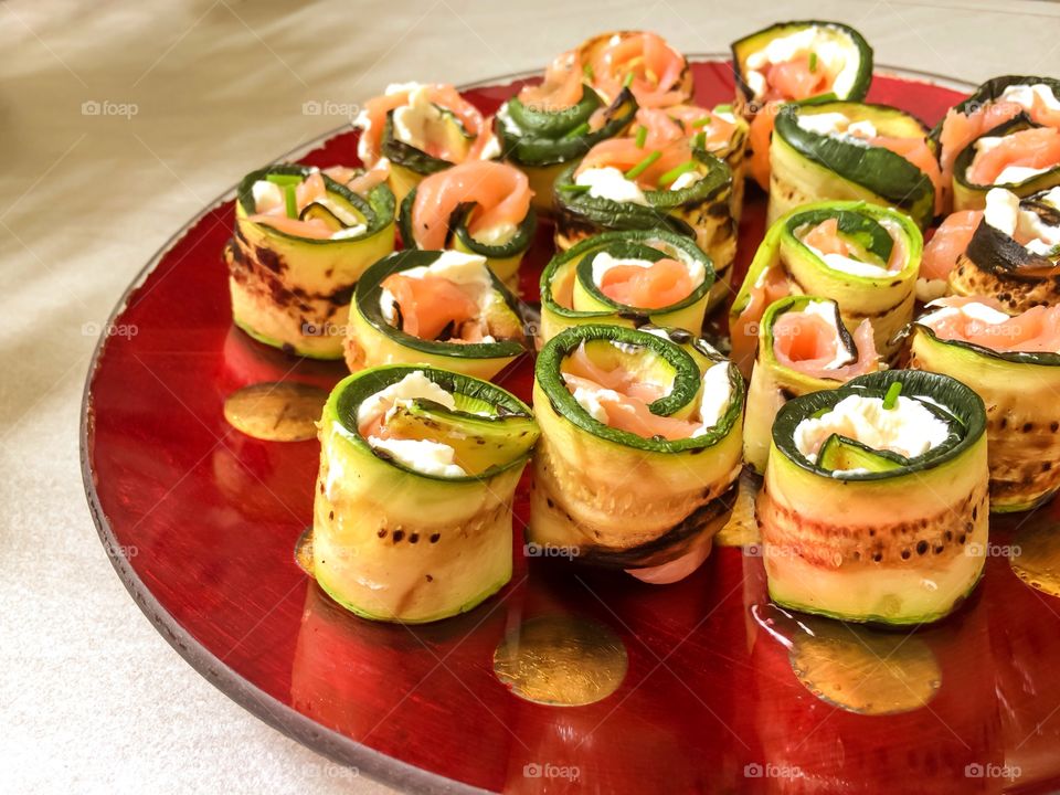 Rolls made with salmon, fresh cheese wrappend with grilled zucchini slices
