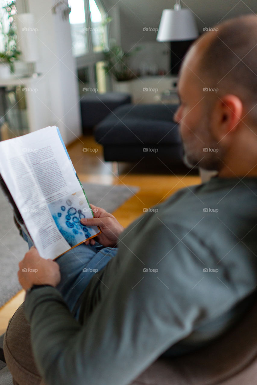 man is reading a magazine - article of corona virus