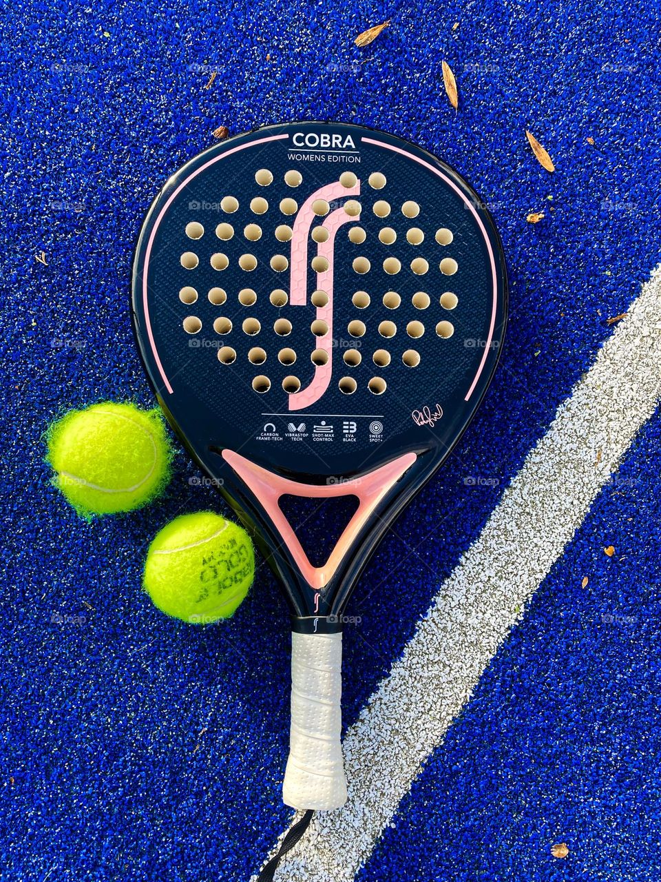 Padel racket with padel balls on a padel court