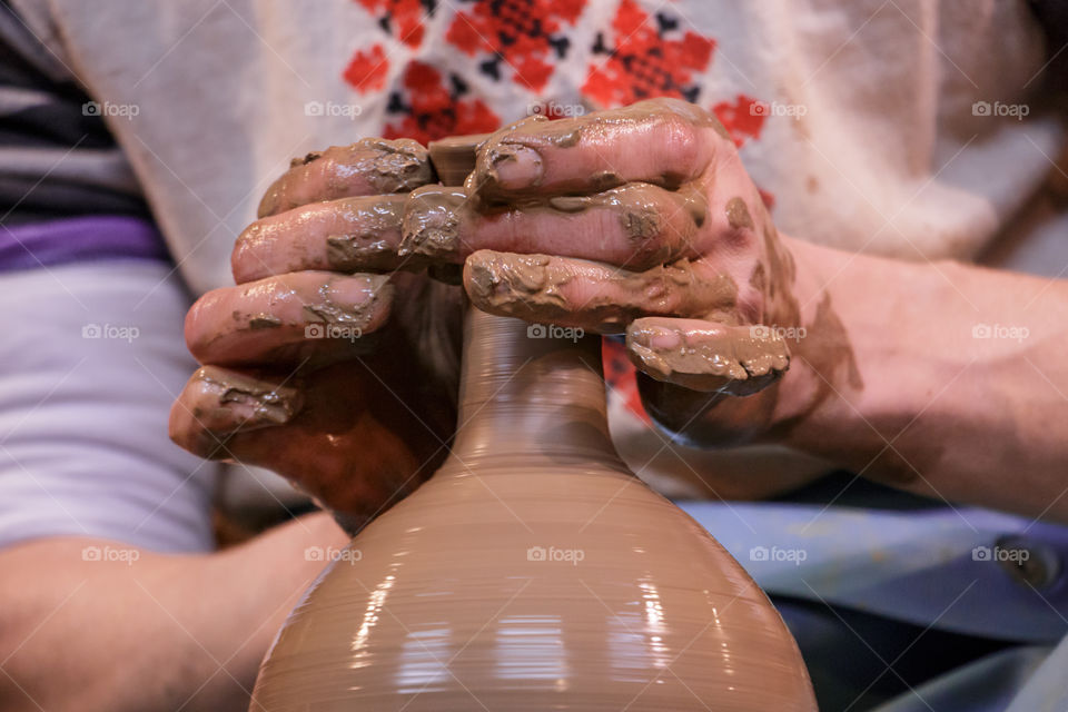 Learning pottery - man making a pot of clay