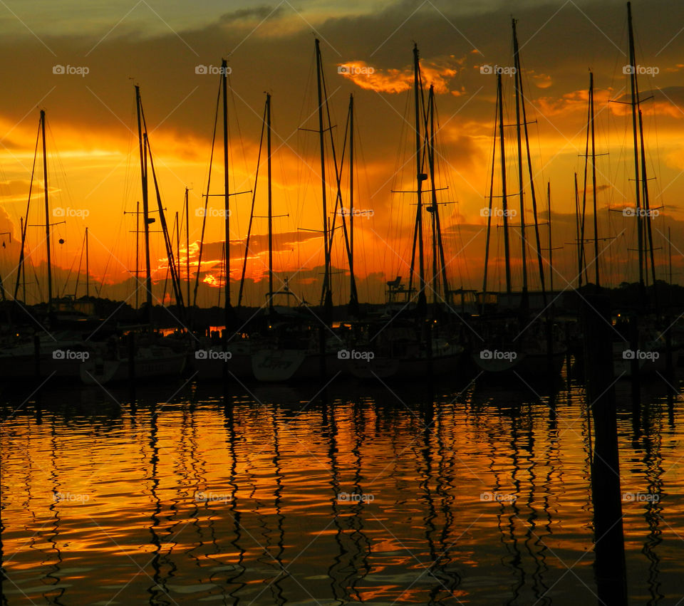 Sailboat Roundup! A brilliant sunset settles on a formation of idle sailboats as it discharges its radiant colors across the sky! 