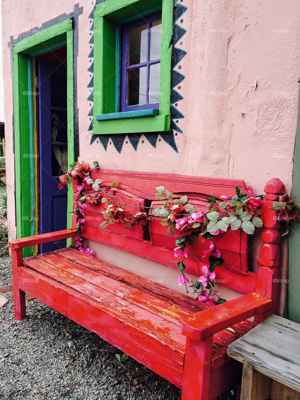 Empty red bench beside the wall