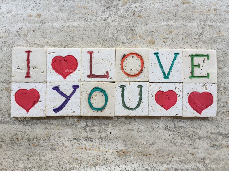 I love you with many hearts. Travertine colored carved pieces for a love message