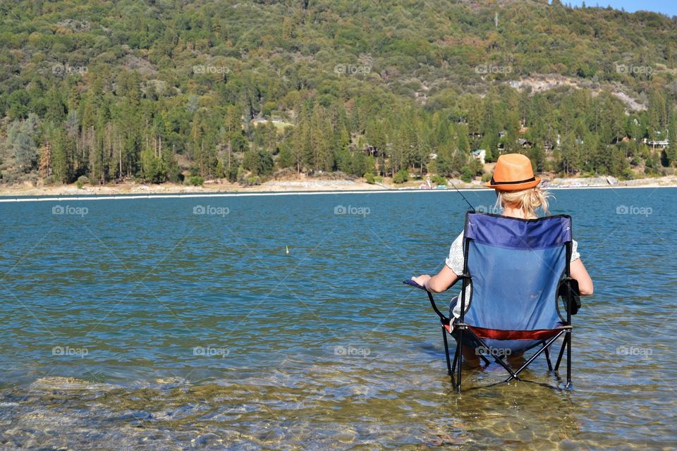 A rear view of woman sitting on chair