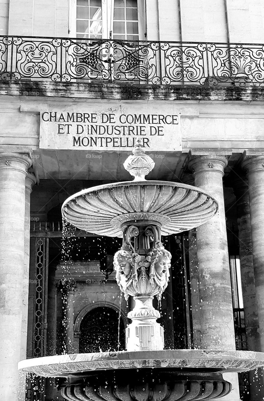 Black and white close up shot on the Art Deco stone fountain and a balcony rail in Montpellier