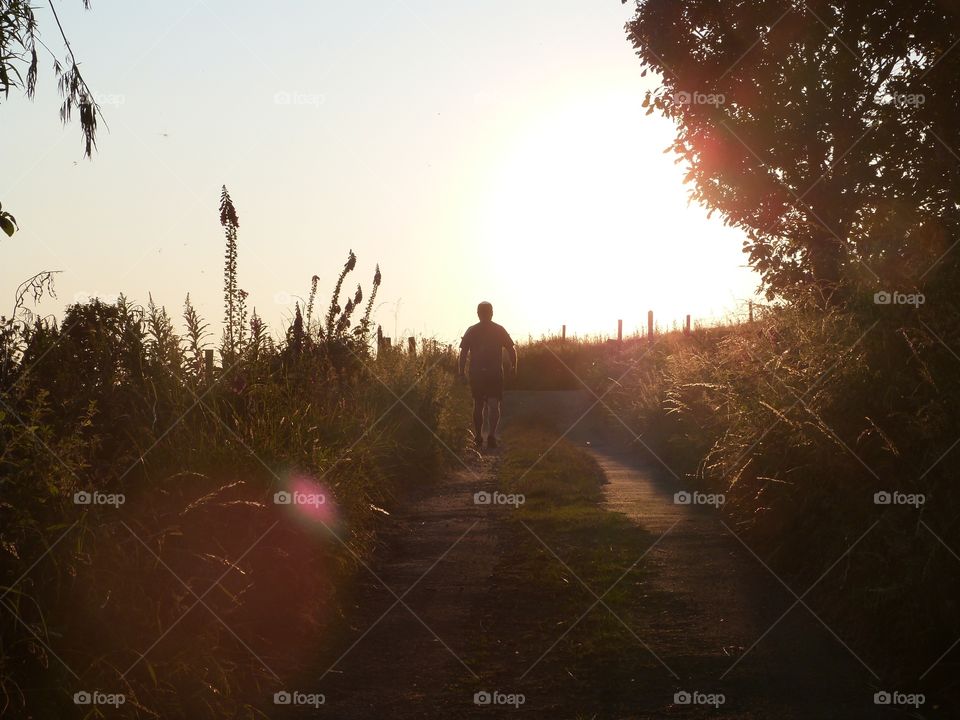 Evening walk on a country path with the sun setting and casting shadows

I'm