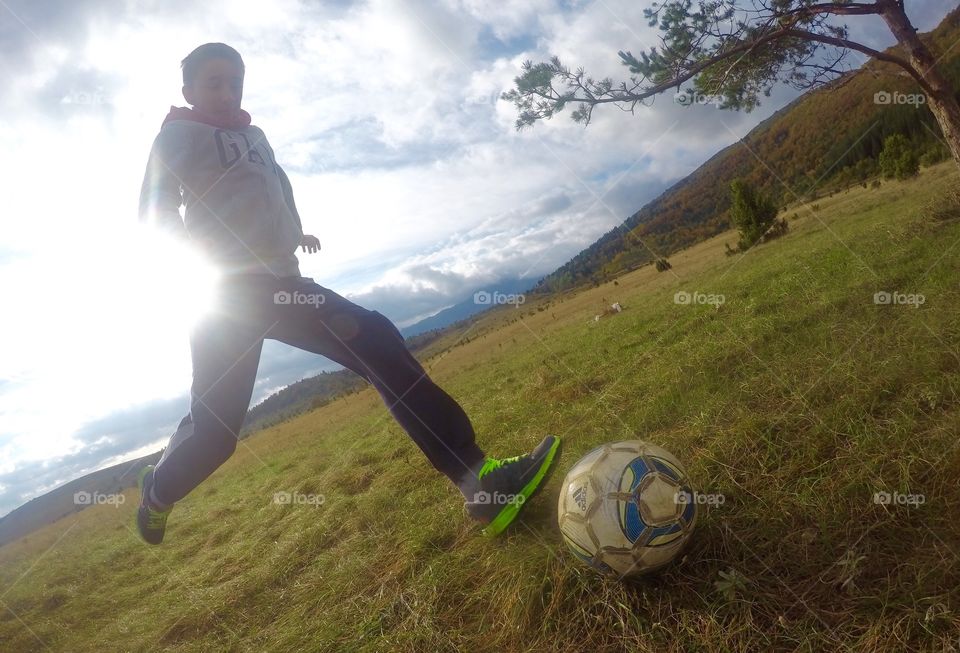 Young boy playing football soccer game on field