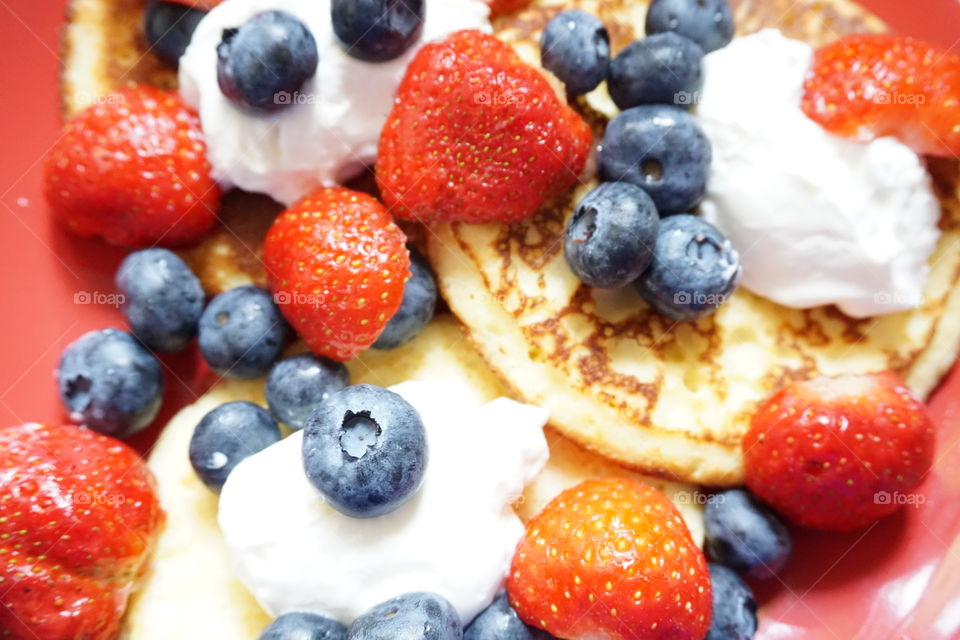 Healthy breakfast, pancakes with strawberries and blueberries