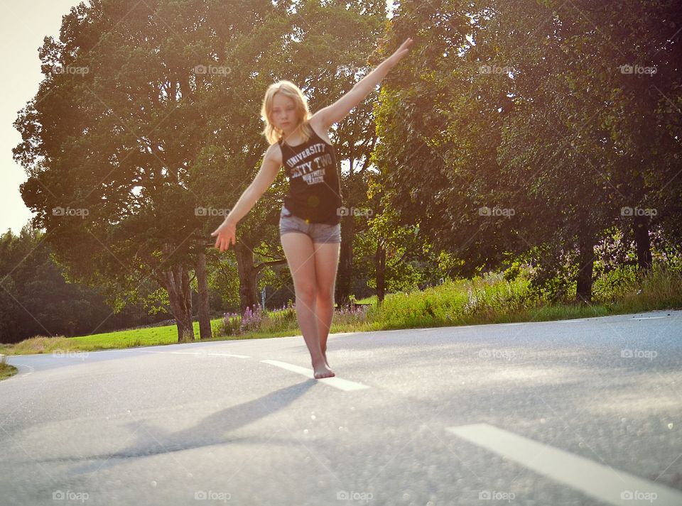 Balance. A girl balances on the road