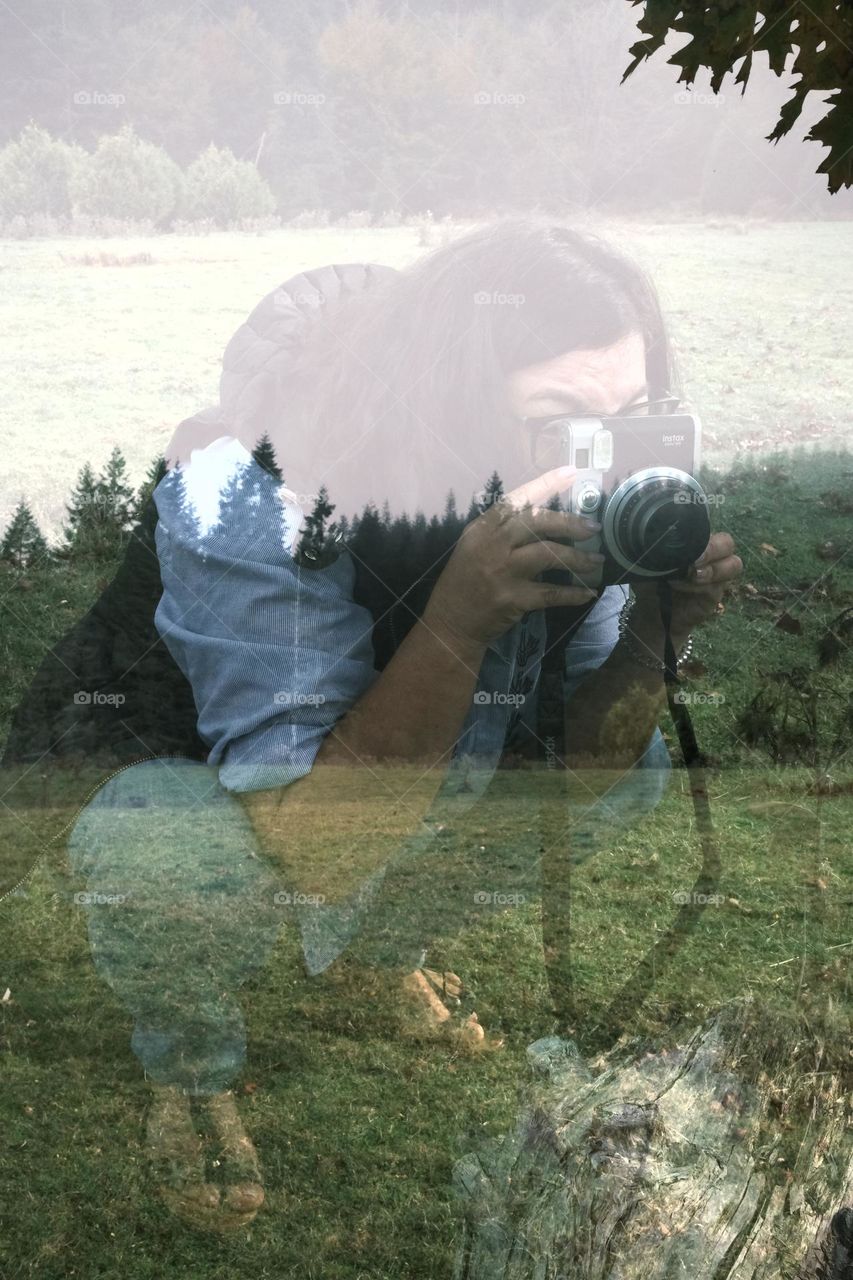 A woman taking photo with a camera she is holding 