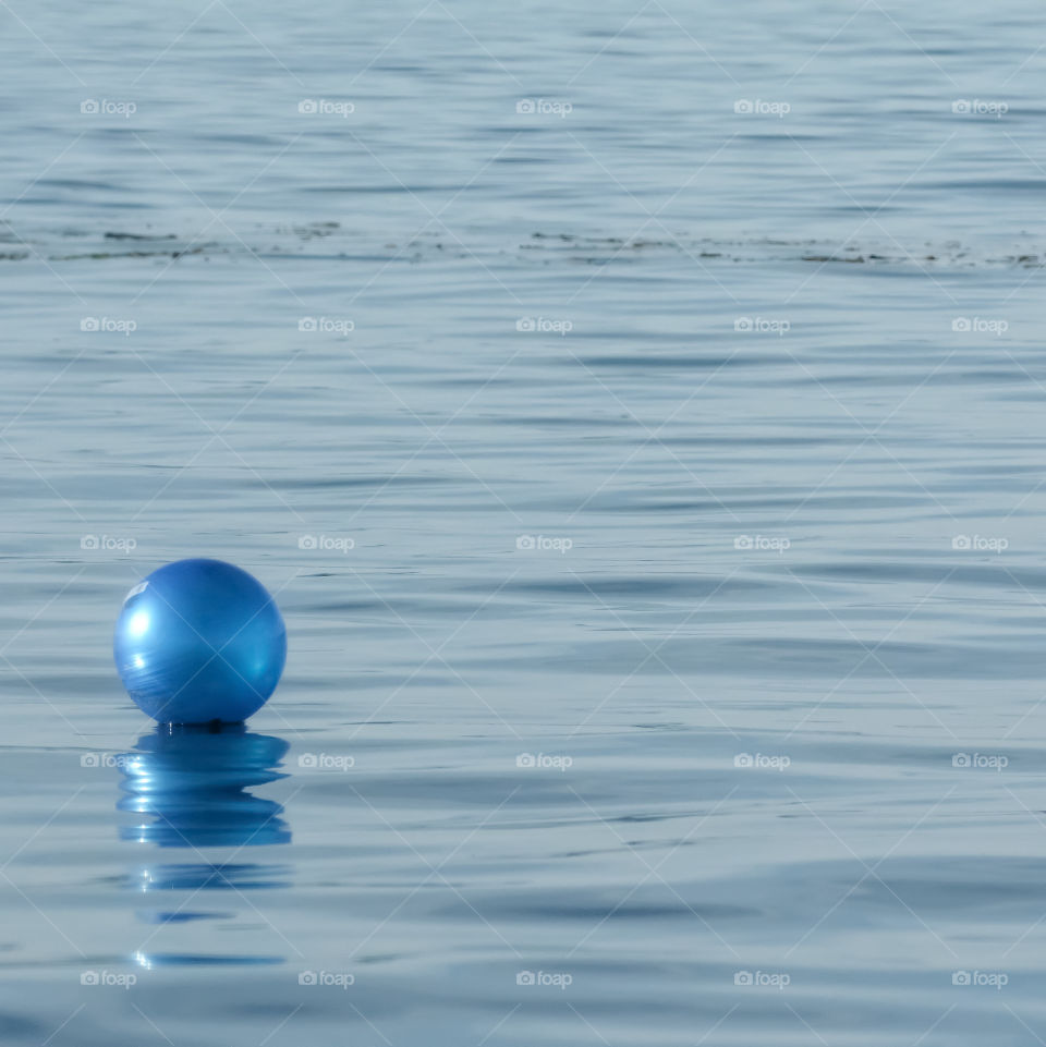 Blue ball adrift at sea