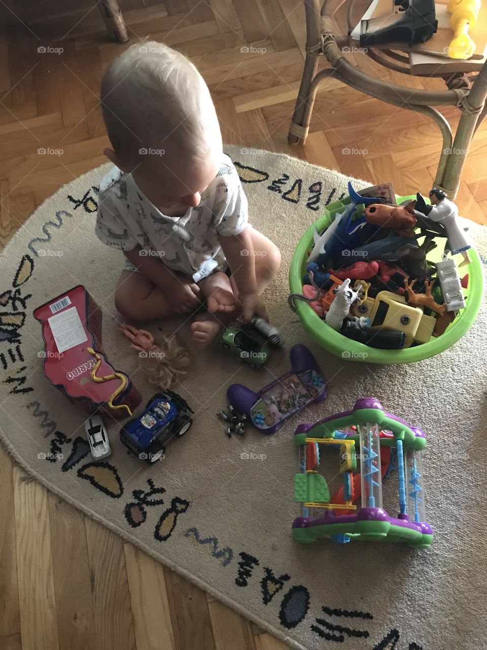 A small child is playing with his toys on the floor