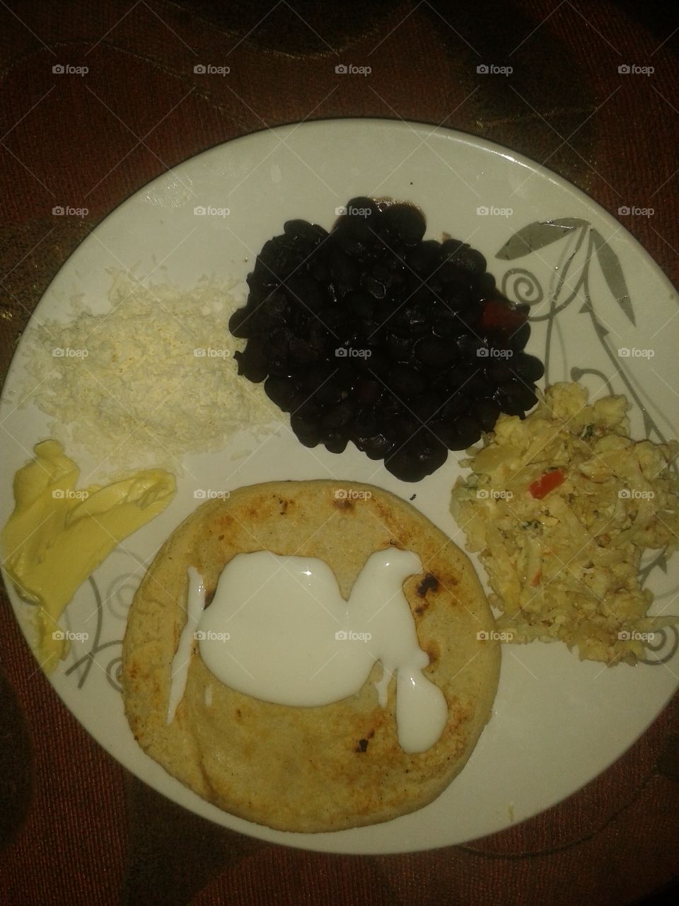Venezuelan food, Arepa, caraotas, egg, butter and cheese.