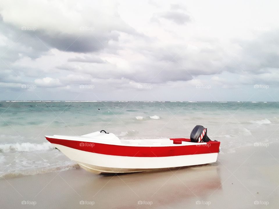 white boat with a red stripe on the ocean in the Dominican Republic