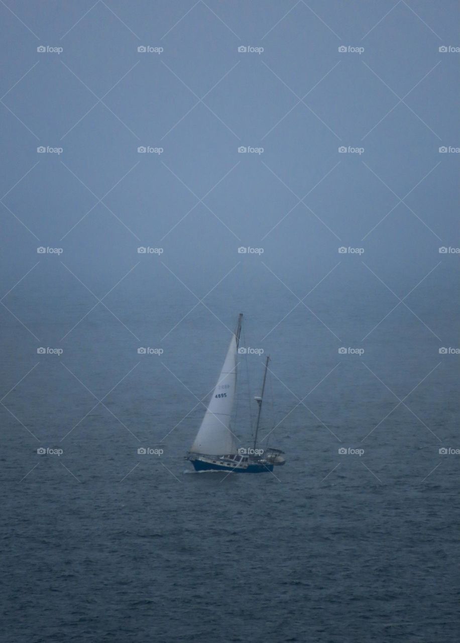 Boat sailing on the ocean on a foggy day.