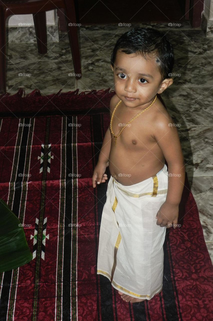 baby wearing traditional clothes and a chain