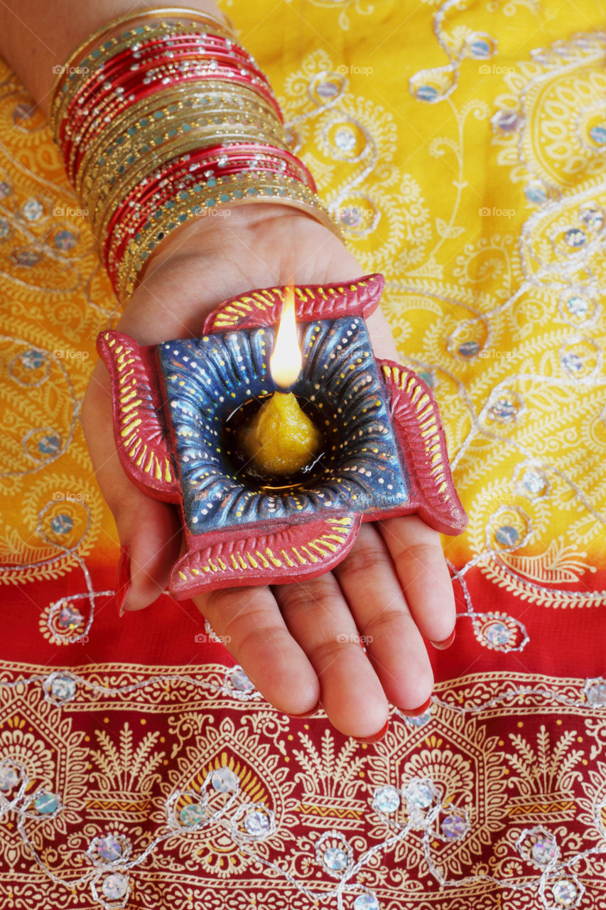 Indian festival Diwali diya oil lamp on female hand