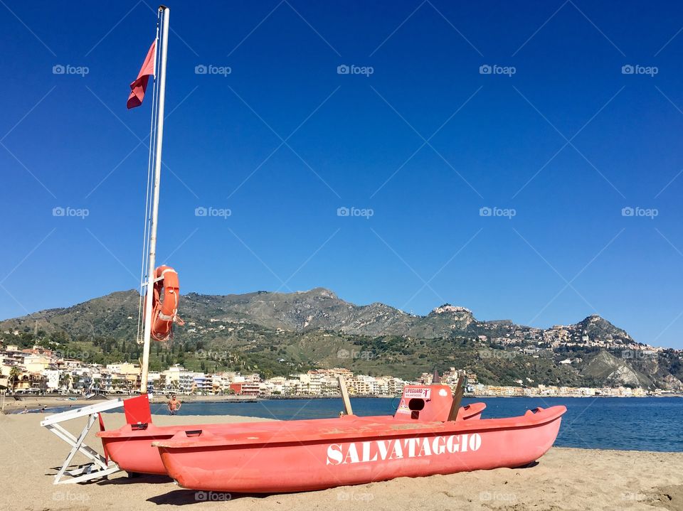 Red lifeguard boat on the beach at Giardini-Naxos, Sicily, Italy