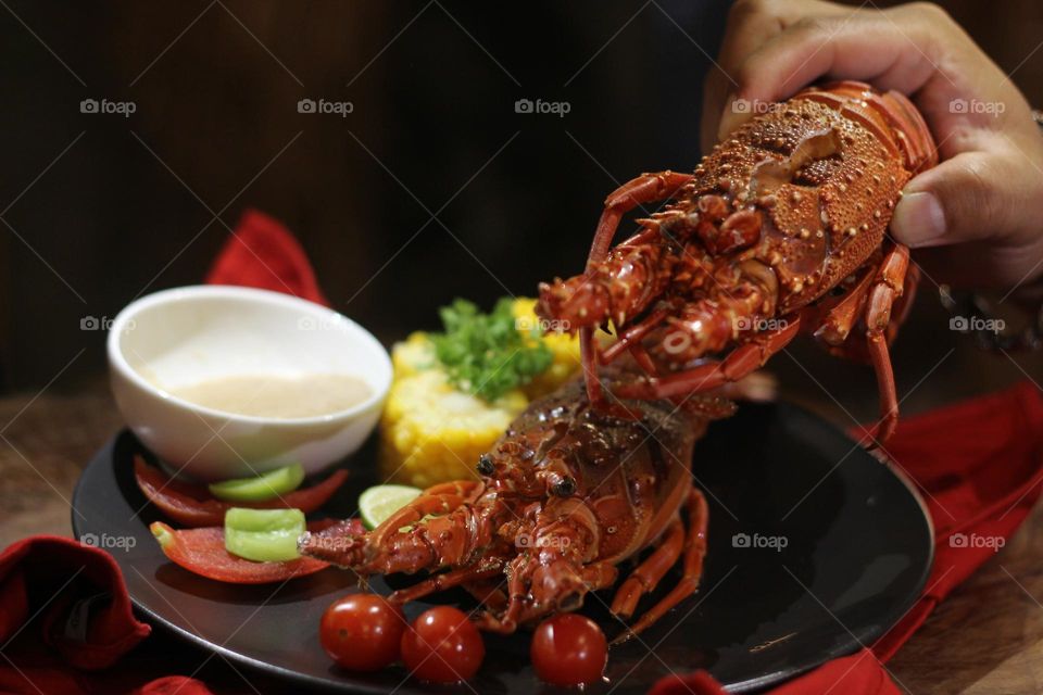 Lobster creamy garlic Lobster served with corn, tomatoes, lemon wedges, cherry and Asian-style creamy garlic sauce.