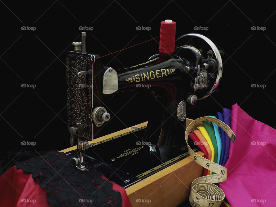 Vintage Singer sewing machine, with swatches of colored fabric and lace
