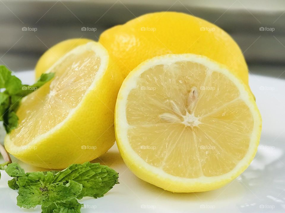 Lemon slices with mint leaves on white plate 