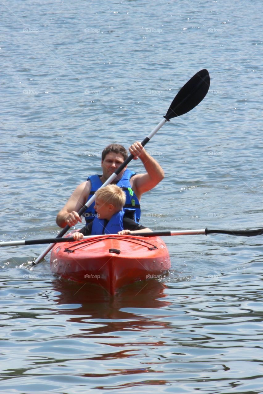 Father and son enjoying kayaking in sea