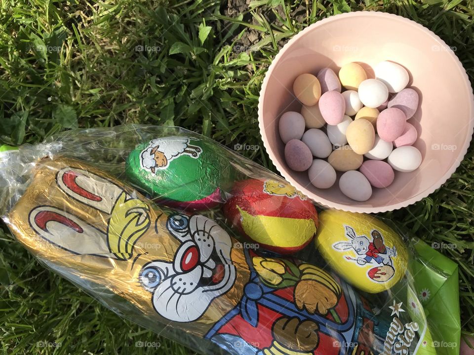 Basket of colorful easter eggs, sweet chocolate eggs, and the chocolate easter bunny