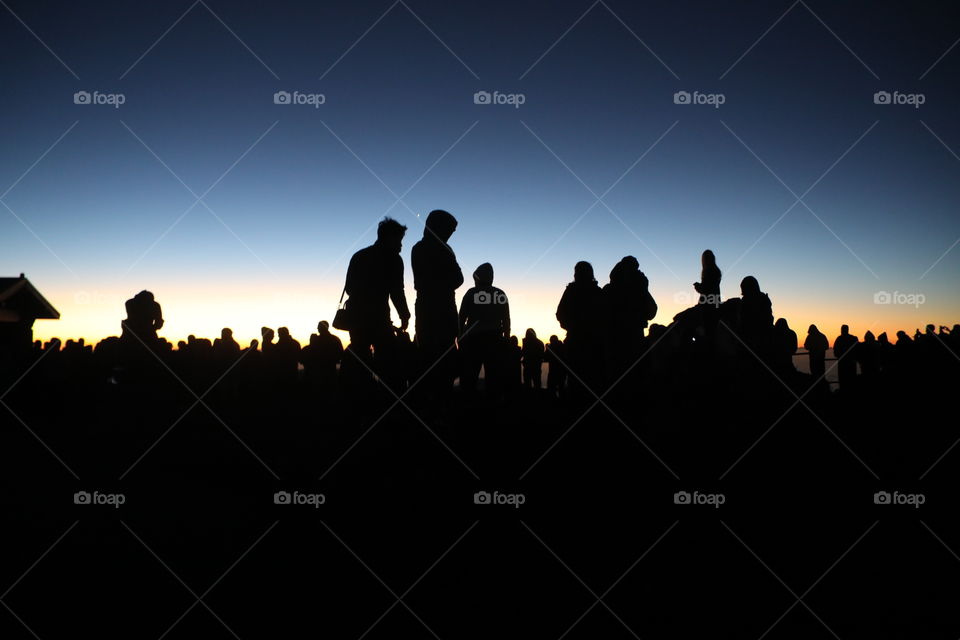 silhouette of travellers waiting for the sunrise