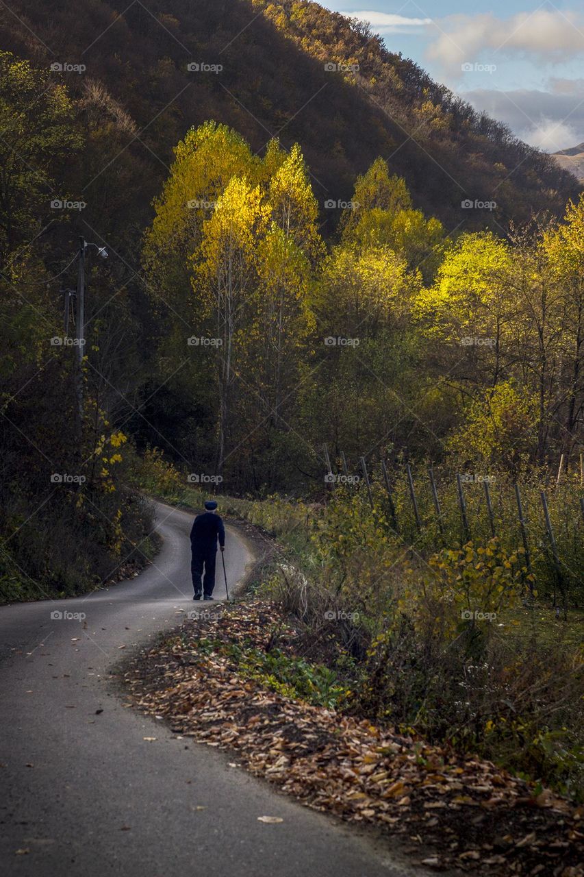 Old man walking down the road