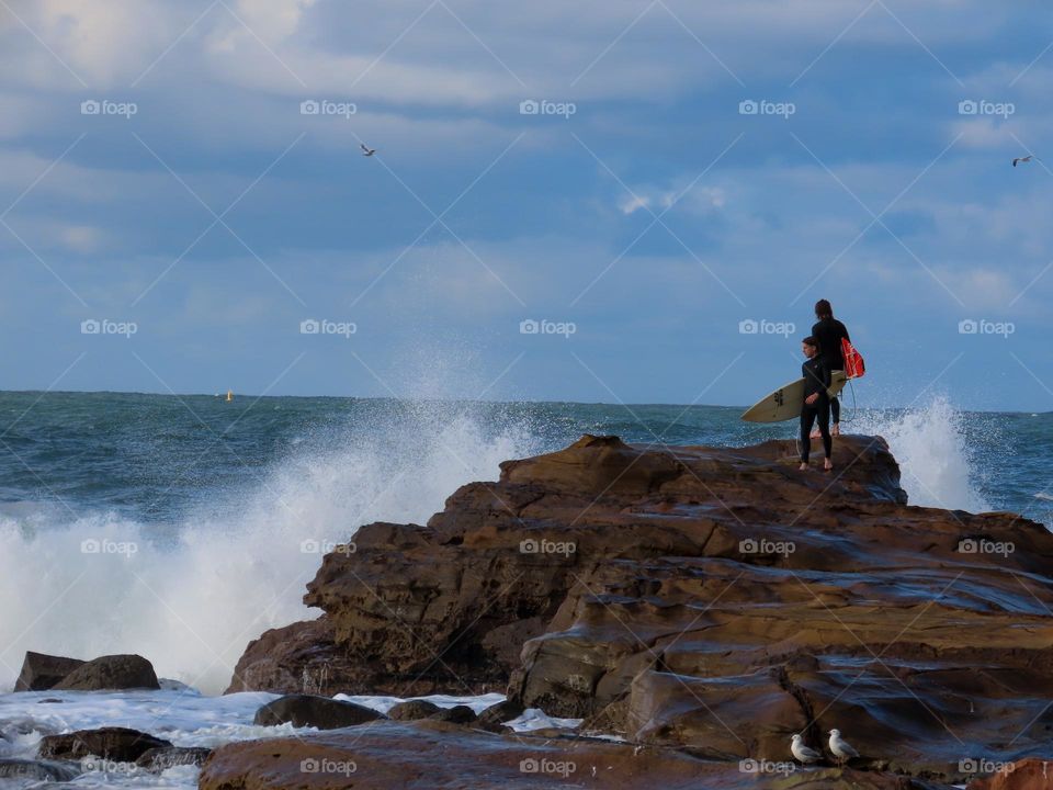 Surfers on a rock 