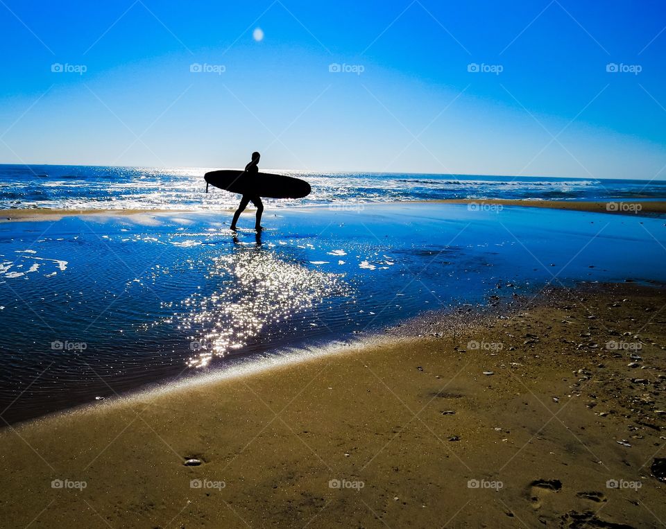 Surfer silhouette at sunset.