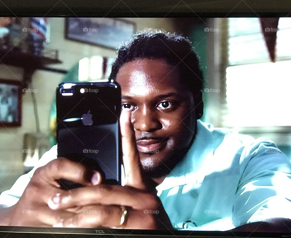 Commercial of a guy taking pictures on a cell phone 