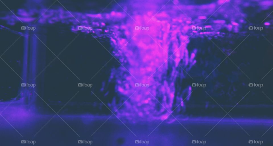 Spilling water into the tank causes an overflow of bubbles to the surface of the water