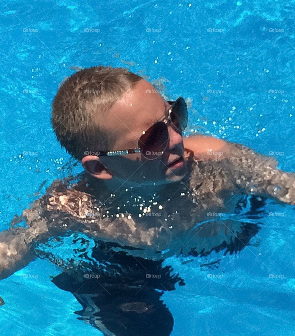 Boy with swimming in blue water