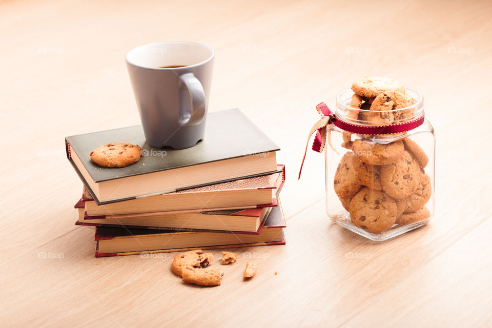 A few books with cup of coffee and cookies on wooden floor. Time for relax. Spending leisure time on reading