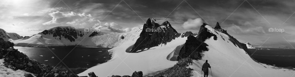 A hiker treks along a ridge on the Antarctic Peninsula.