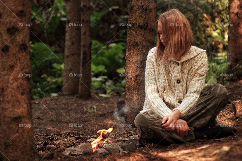 Girl resting by the camping fire in the mountains