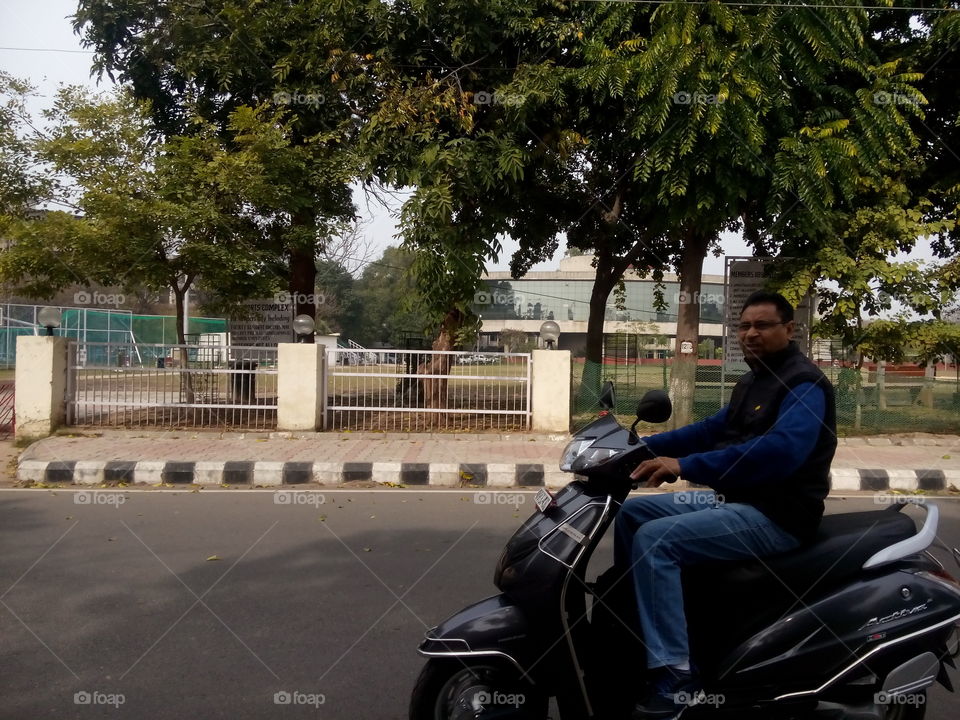 street activa biking riding garden trees gate